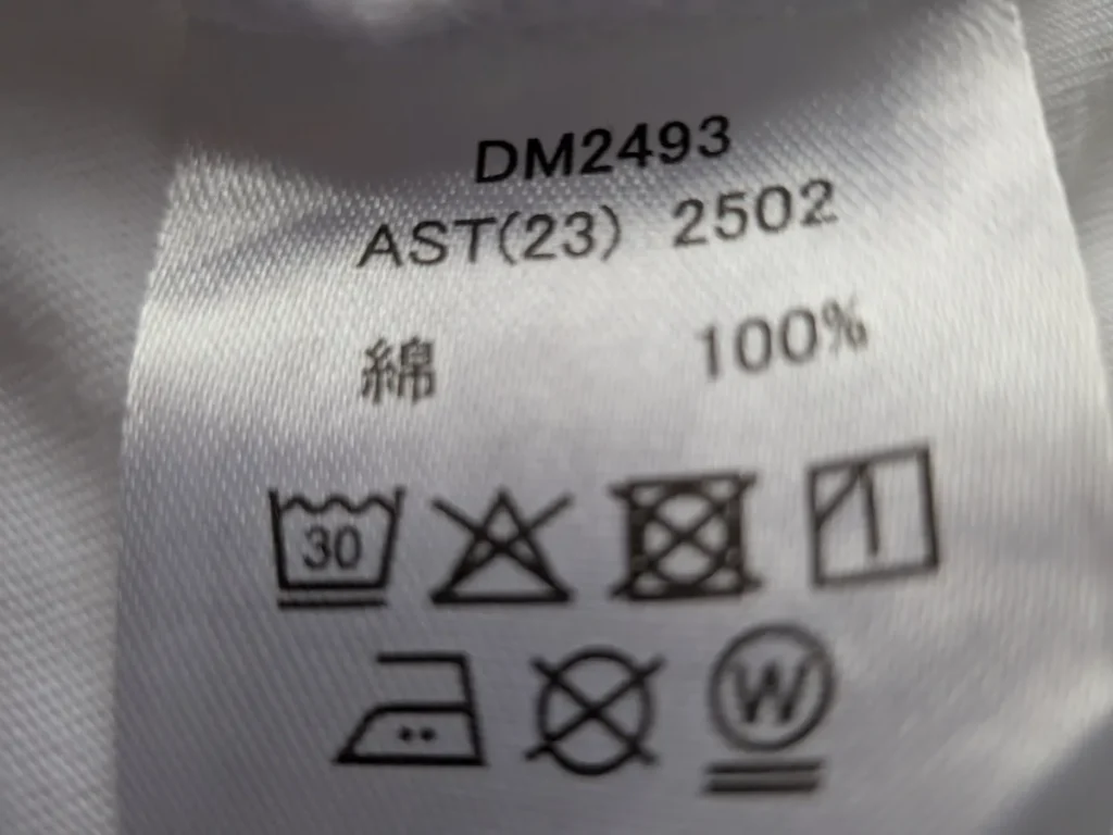 素材が綿100%と書かれた服の品質表示タグ